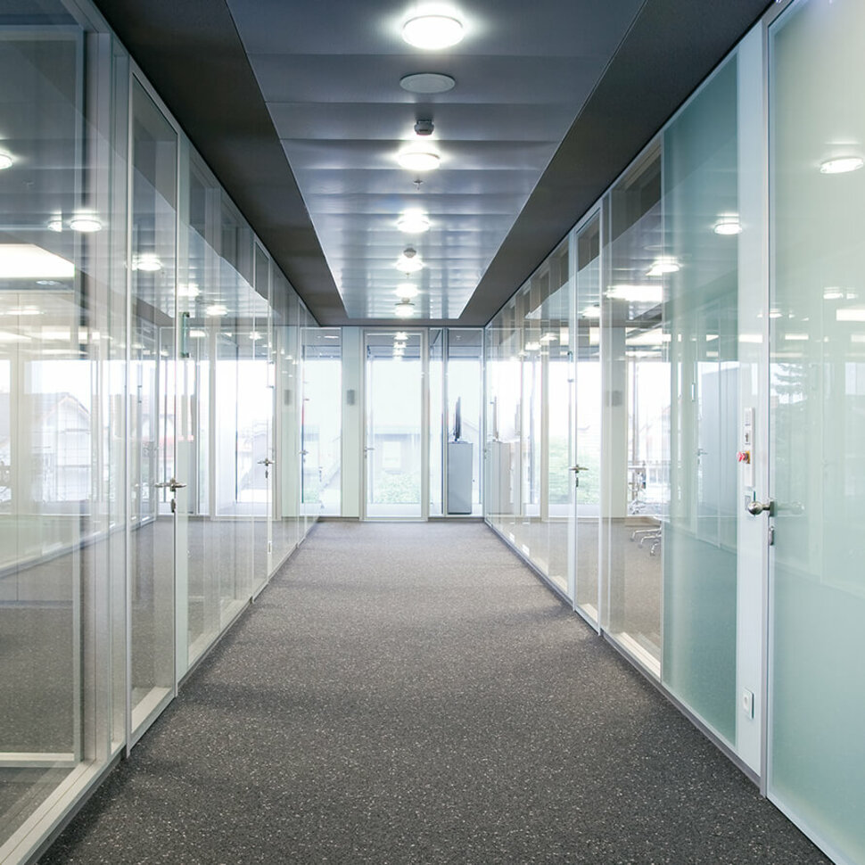 Moderner Büroflur mit Glaswänden zur Abtrennung der Büroräume